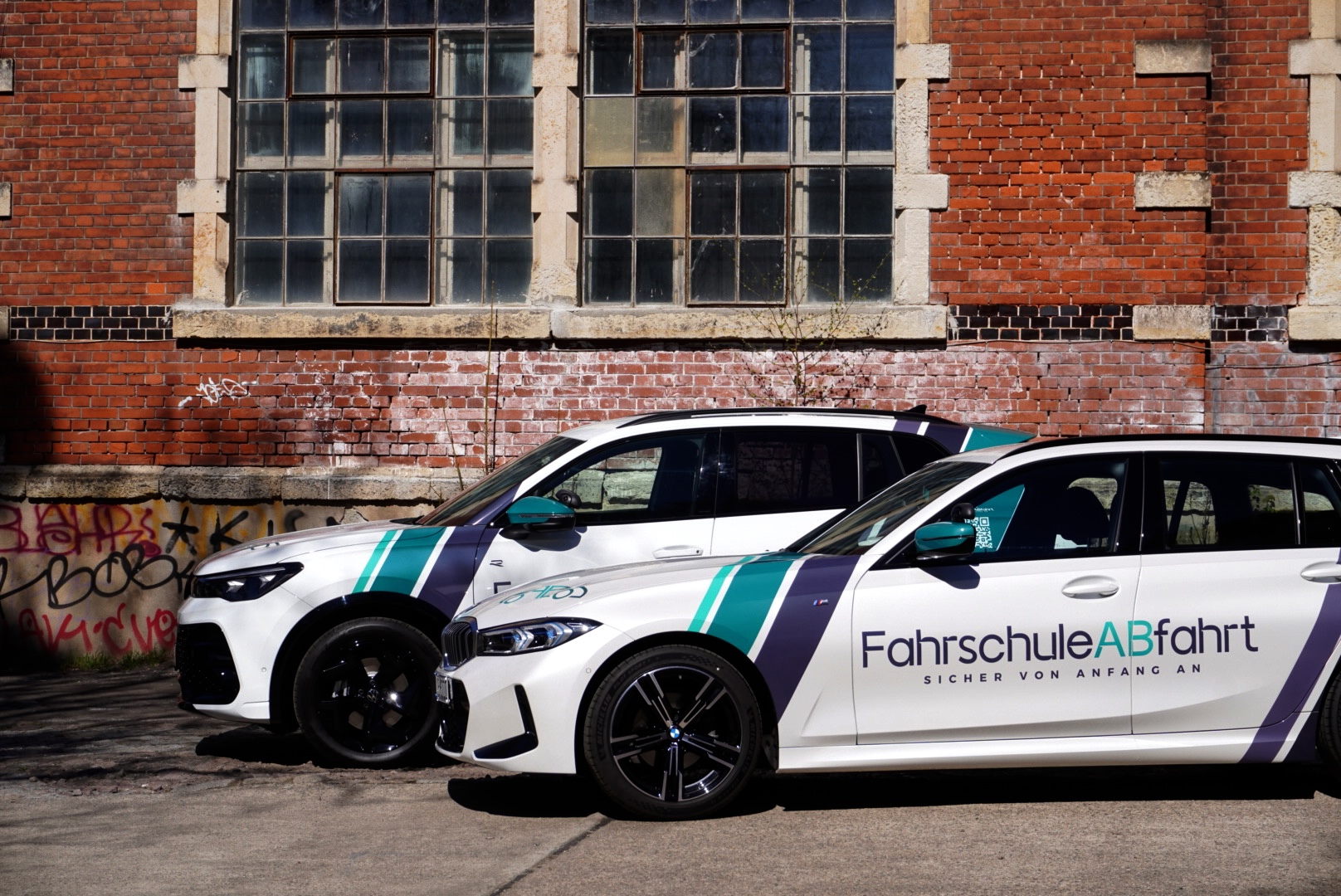 Zwei Fahrzeuge der Fahrschule ABfahrt von der Seite fotografiert